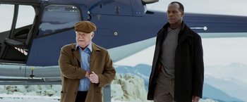 Movie still from “Shooter” (2007), directed by Antoine Fuqua – Two men standing next to each other in front of an airplane; Medium shot, Low angle