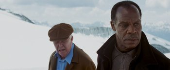Movie still from “Shooter” (2007), directed by Antoine Fuqua – Two older men standing next to each other in the snow; Medium shot, Low angle
