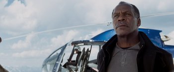 Movie still from “Shooter” (2007), directed by Antoine Fuqua – A man standing in front of a helicopter on a cloudy day; Close Up shot, Low angle