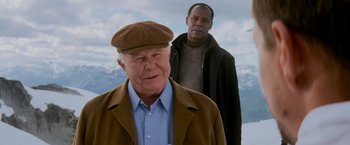 Movie still from “Shooter” (2007), directed by Antoine Fuqua – A man wearing a brown hat and a brown jacket; Medium shot, Over the shoulder angle