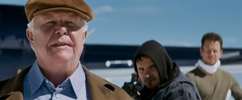 Movie still from “Shooter” (2007), directed by Antoine Fuqua – A man with a gun standing next to another man; Close Up shot, Over the shoulder angle