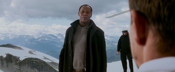 Movie still from “Shooter” (2007), directed by Antoine Fuqua – An older man standing on top of a mountain; Medium shot, Low angle