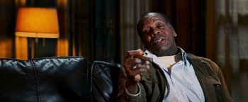 Movie still from “Shooter” (2007), directed by Antoine Fuqua – An older man sitting on a couch looking at his cell phone; Close Up shot, Low angle