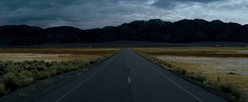 Movie still from “Shooter” (2007), directed by Antoine Fuqua – An empty road in the middle of a field; Extreme Wide shot, High angle