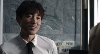 Movie still from “Shortcomings” (2023), directed by Randall Park – A man wearing a white shirt and a black tie; Close Up shot, Over the shoulder angle