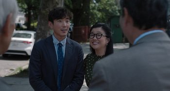 Movie still from “Shortcomings” (2023), directed by Randall Park – A man and a woman standing next to each other on the street; Medium shot, Over the shoulder angle