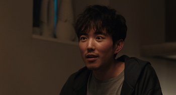 Movie still from “Shortcomings” (2023), directed by Randall Park – A person wearing a jacket; Close Up shot, Over the shoulder angle