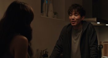 Movie still from “Shortcomings” (2023), directed by Randall Park – A man and a woman are talking in a room; Medium shot, Over the shoulder angle