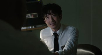 Movie still from “Shortcomings” (2023), directed by Randall Park – A man wearing a white shirt and a black tie; Close Up shot, Over the shoulder angle