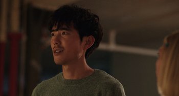 Movie still from “Shortcomings” (2023), directed by Randall Park – A man with a beard is looking to his left; Close Up shot, Over the shoulder angle