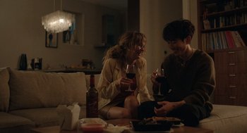 Movie still from “Shortcomings” (2023), directed by Randall Park – Two people sitting at a table drinking wine; Medium shot, Over the shoulder angle