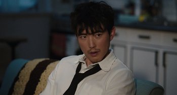 Movie still from “Shortcomings” (2023), directed by Randall Park – A man in a white shirt and a black tie; Close Up shot, Over the shoulder angle