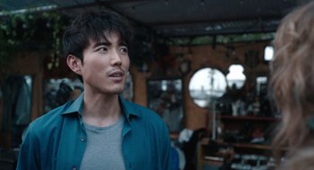 Movie still from “Shortcomings” (2023), directed by Randall Park – A young man in a blue shirt is looking up; Close Up shot, Over the shoulder angle