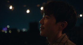 Movie still from “Shortcomings” (2023), directed by Randall Park – A young man is looking up at the sky at night; Close Up shot, Over the shoulder angle