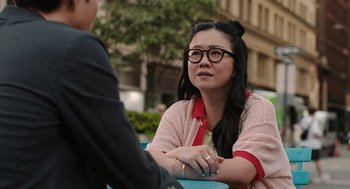 Movie still from “Shortcomings” (2023), directed by Randall Park – A woman sitting at an outdoor table with a man; Close Up shot, Over the shoulder angle