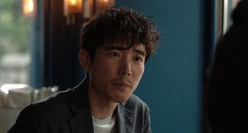 Movie still from “Shortcomings” (2023), directed by Randall Park – A person wearing a jacket; Close Up shot, Over the shoulder angle