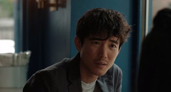Movie still from “Shortcomings” (2023), directed by Randall Park – A person wearing a jacket; Close Up shot, Over the shoulder angle