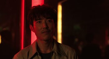 Movie still from “Shortcomings” (2023), directed by Randall Park – A person wearing a shirt; Close Up shot, Over the shoulder angle