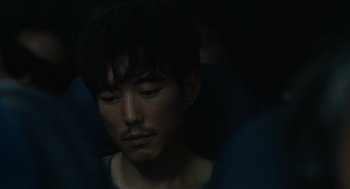 Movie still from “Shortcomings” (2023), directed by Randall Park – A person with his eyes closed; Close Up shot, High angle