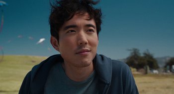 Movie still from “Shortcomings” (2023), directed by Randall Park – A person with a bird flying in the background; Close Up shot, Over the shoulder angle