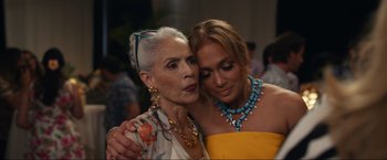 Movie still from “Shotgun Wedding” (2022), directed by Jason Moore – A woman hugging a woman in a yellow dress; Close Up shot, Over the shoulder angle