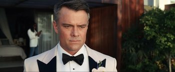 Movie still from “Shotgun Wedding” (2022), directed by Jason Moore – A person wearing a suit and a bow tie; Close Up shot, Over the shoulder angle