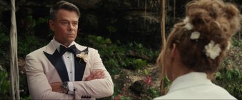 Movie still from “Shotgun Wedding” (2022), directed by Jason Moore – A man in a white suit standing next to a woman in a white suit; Close Up shot, Over the shoulder angle