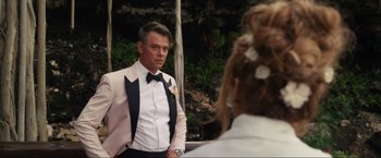 Movie still from “Shotgun Wedding” (2022), directed by Jason Moore – A man in a tuxedo looking at a woman in a white suit; Medium shot, Over the shoulder angle