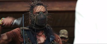 Movie still from “Shotgun Wedding” (2022), directed by Jason Moore – A man with a spiked mask on his face; Close Up shot, Over the shoulder angle