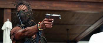 Movie still from “Shotgun Wedding” (2022), directed by Jason Moore – A man holding a gun in his right hand; Close Up shot, Low angle