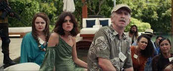 Movie still from “Shotgun Wedding” (2022), directed by Jason Moore – A man and a woman sitting next to each other on a patio; Medium shot, Low angle