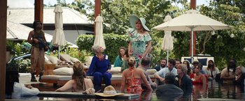 Movie still from “Shotgun Wedding” (2022), directed by Jason Moore – A group of people sitting around a swimming pool; Wide shot, Over the shoulder angle