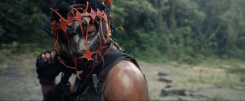 Movie still from “Shotgun Wedding” (2022), directed by Jason Moore – A man with a mask on is standing in the woods; Close Up shot, Low angle