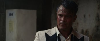 Movie still from “Shotgun Wedding” (2022), directed by Jason Moore – A person wearing a suit and tie; Close Up shot, Over the shoulder angle