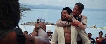 Movie still from “Shotgun Wedding” (2022), directed by Jason Moore – A man hugging another man on the beach; Medium shot, Over the shoulder angle
