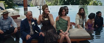 Movie still from “Shotgun Wedding” (2022), directed by Jason Moore – A group of people sitting next to each other on a bench; Medium shot, Over the shoulder angle