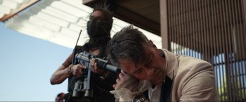 Movie still from “Shotgun Wedding” (2022), directed by Jason Moore – A man in a tie and a man in a black shirt and a man in a black and white tie and a man in a black and white; Medium shot, Low angle