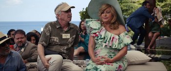 Movie still from “Shotgun Wedding” (2022), directed by Jason Moore – An older man and woman sitting next to each other; Medium shot, Over the shoulder angle