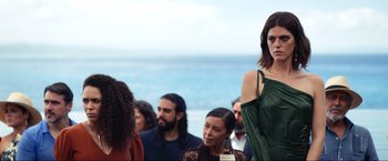 Movie still from “Shotgun Wedding” (2022), directed by Jason Moore – A group of people standing around a body of water; Medium shot, Over the shoulder angle