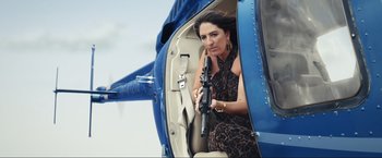 Movie still from “Shotgun Wedding” (2022), directed by Jason Moore – A woman holding a gun while sitting in the cockpit of a helicopter; Medium shot, Low angle