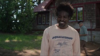 Movie still from “Showing Up” (2022), directed by Kelly Reichardt – A man with a beard is standing in front of a house; Medium shot, Over the shoulder angle