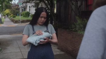 Movie still from “Showing Up” (2022), directed by Kelly Reichardt – A woman is holding a bird in her arms; Medium shot, Over the shoulder angle