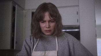Movie still from “Showing Up” (2022), directed by Kelly Reichardt – A woman in an apron looking down at her face; Close Up shot, Over the shoulder angle