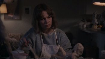 Movie still from “Showing Up” (2022), directed by Kelly Reichardt – A woman wearing an apron and holding a spoon; Close Up shot, Over the shoulder angle