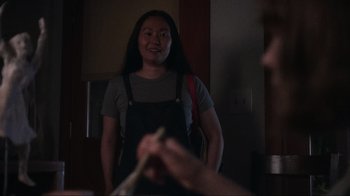 Movie still from “Showing Up” (2022), directed by Kelly Reichardt – A woman in an overalls smiles at the camera; Medium shot, Over the shoulder angle