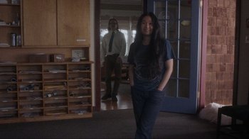 Movie still from “Showing Up” (2022), directed by Kelly Reichardt – A woman standing next to a man in front of a door; Wide shot, Over the shoulder angle
