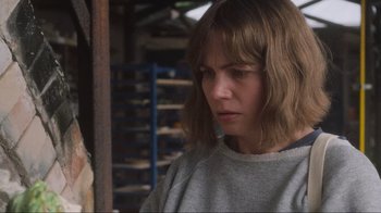Movie still from “Showing Up” (2022), directed by Kelly Reichardt – A person wearing a sweater; Close Up shot, Over the shoulder angle