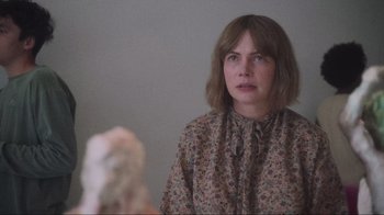 Movie still from “Showing Up” (2022), directed by Kelly Reichardt – A woman in a floral shirt looking at the camera; Close Up shot, Over the shoulder angle