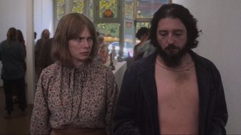 Movie still from “Showing Up” (2022), directed by Kelly Reichardt – A man and a woman standing next to each other; Medium shot, Low angle