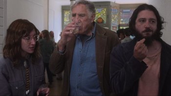 Movie still from “Showing Up” (2022), directed by Kelly Reichardt – An older man is drinking from a glass; Medium shot, Over the shoulder angle